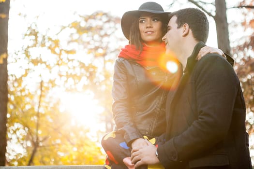 Beautiful happy couple in autumn park relaxing