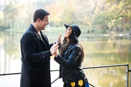 Beautiful gourgeous couple walking in autumn park near a lake