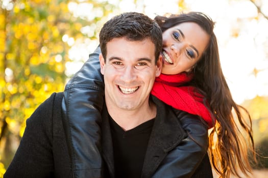 Amazing funny young couple in autumn park having fun