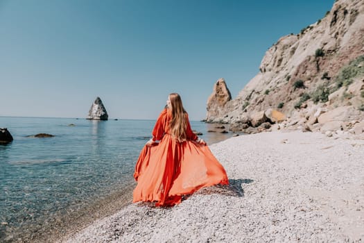 Woman travel sea. Happy tourist taking picture outdoors for memories. Woman traveler looks at the edge of the cliff on the sea bay of mountains, sharing travel adventure journey.