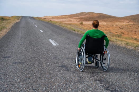 Woman in a wheelchair on a highway in the steppes