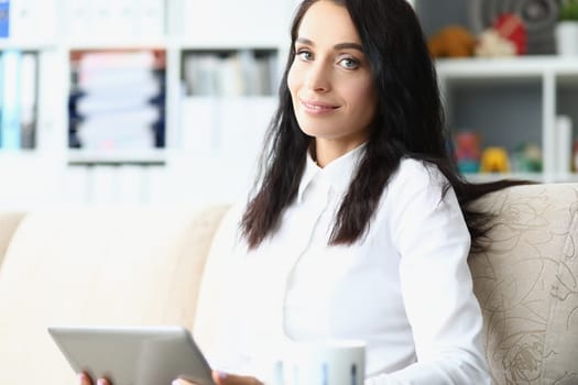 Happy attractive business woman holding tablet. Smiling pleasant young woman planning work day
