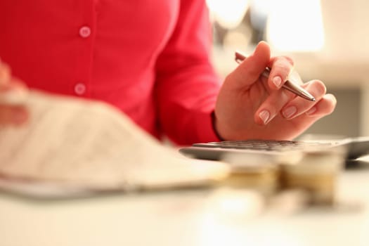 Hand of business woman points finger at the financial table counting calculator. Tax inspector checks investment audit statistics and income