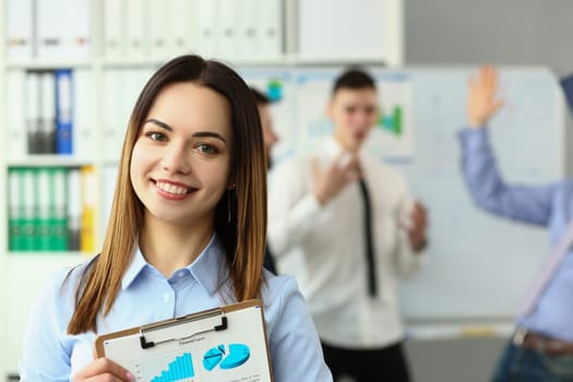 Business woman with staff and group of people in background in office. Educational seminar lecture concept