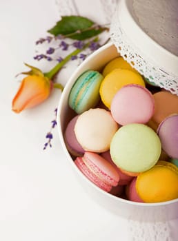 Colorful macaroons in a gift box on a white table