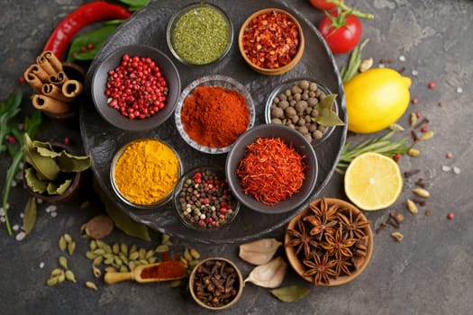 Multicolored herbs and spices for cooking. Indian spices. Against the background of black stone. View from above.