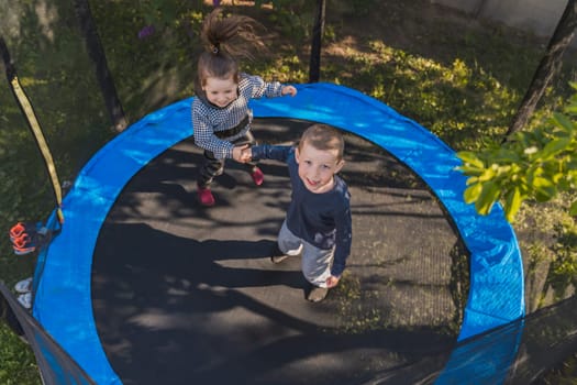 children jumping on a trampoline top view