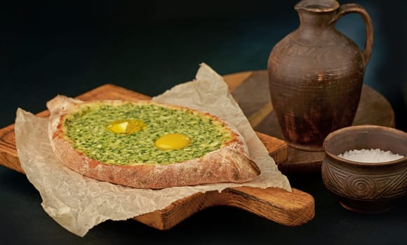 Ajarian khachapuri, filled with cheese and topped with a raw egg and butter, traditional Georgian Khachapuri with cheese-filled bread