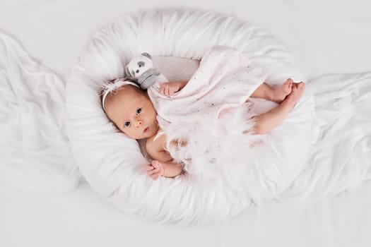 sweet newborn baby sleeping with teddy bear toy on white background