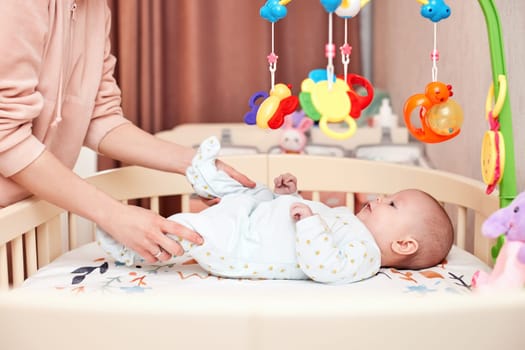 Baby massage. Mother doing strengthening exercises for babies, early development