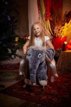 Beautiful girl in a white dress on the background of a Christmas tree. New year and christmas concept