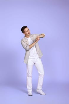 handsome man in casual shirt posing on pastel purple background. Full length photo