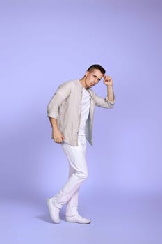 optimistic caucasian man dancing on pastel violet background. vacation summer. Full body