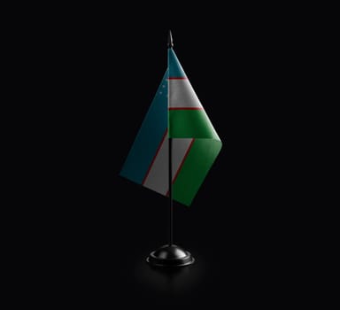 Small national flag of the Uzbekistan on a black background.