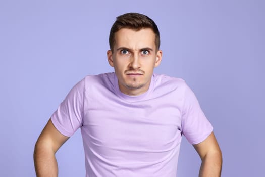 annoyed angry man on pastel purple studio background
