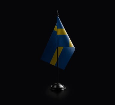 Small national flag of the Sweden on a black background.