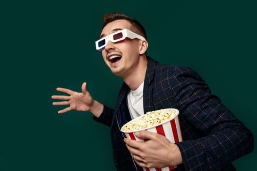 handsome man in 3d glasses and plaid jacket with popcorn on green background.