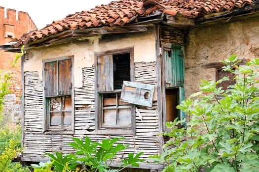 Facade of an old abandoned village house destroyed by time