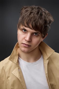 close-up portrait of serious man with hairstyle in coat on black background. fashion modern style look