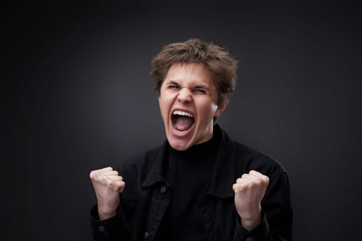 annoyed angry man in furious gesture on black studio background