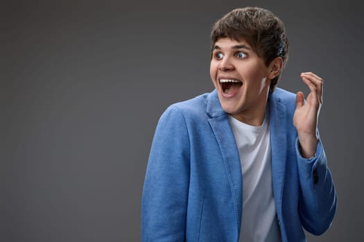 happy shocked man with surprise expression and excited face on gray studio background