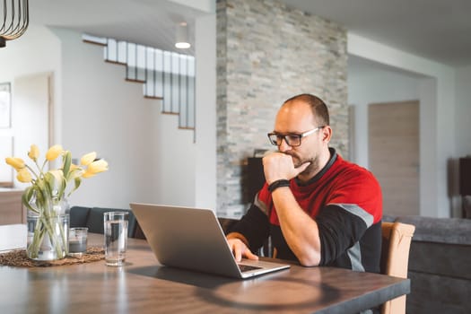 Adult caucasian man working from home a couple days a week. Adult person working from home, from different rooms in the house, in the kitchen, dining room, office.