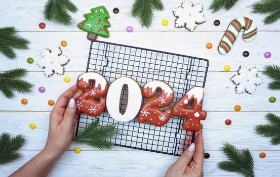 Gingerbread cookies in the form of numbers 2024 are laid out on a metal grid