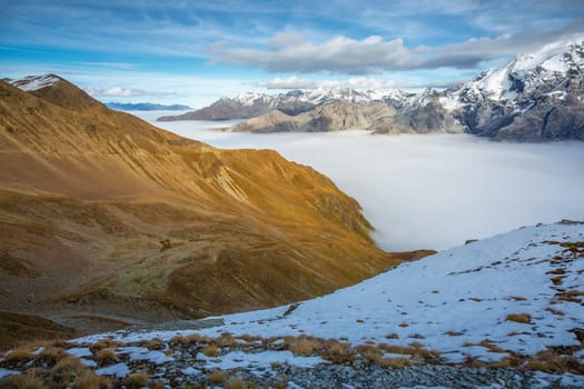 Stelvio pass, mountain dramatic landscape at dawn above mist, Northern Italy