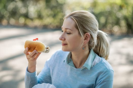 Dutch blonde woman eating fresh harring in Amsterdam city