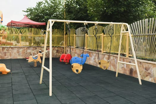 Various Children's toys on the playground. Swing carousel in the park