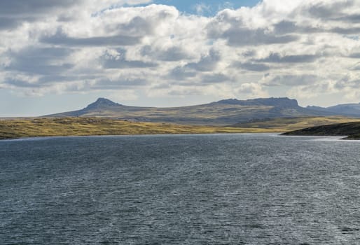 Rugged headlands and rocks when approaching the port of Stanley on the Falkland Islands from the ocean