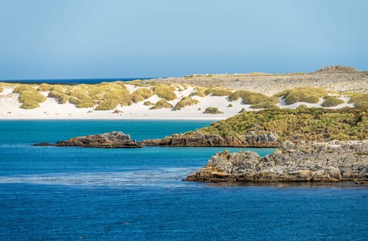 Sandy beaches and rocks when approaching the port of Stanley on the Falkland Islands from the ocean