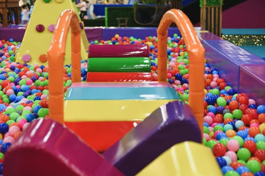 A dry paddling pool in playing centre with balls.