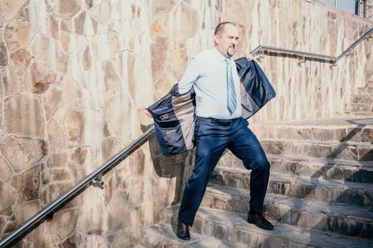 Portrait of a senior professional man in a suit with various problems. A middle-aged businessman with a briefcase descends the stairs.