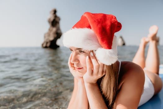 Close up shot of happy young caucasian woman looking at camera and smiling. Cute woman portrait in bikini posing on a volcanic rock high above the sea