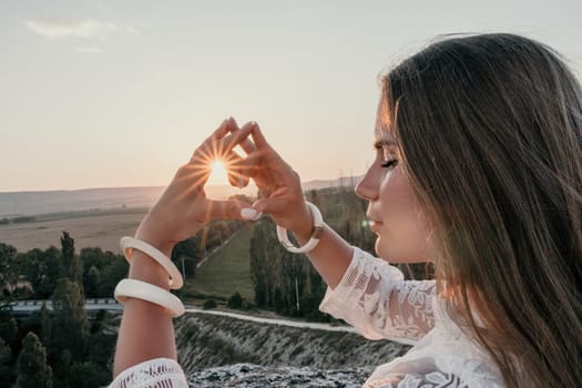 Romantic beautiful bride in white dress posing with sea and mountains in background. Stylish bride standing back on beautiful landscape of sea and mountains on sunset