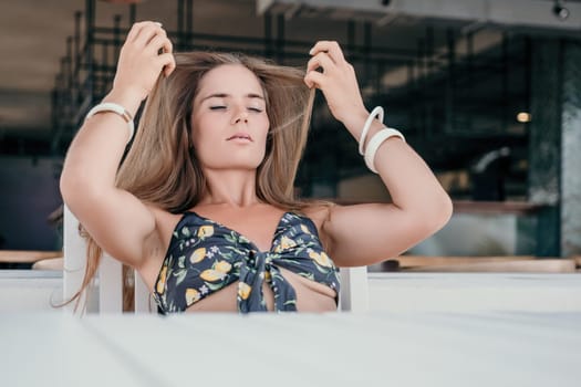 Happy woman portrait in cafe. Boho chic fashion style. Outdoor photo of young happy woman with long hair, sunny weather outdoors sitting in modern cafe