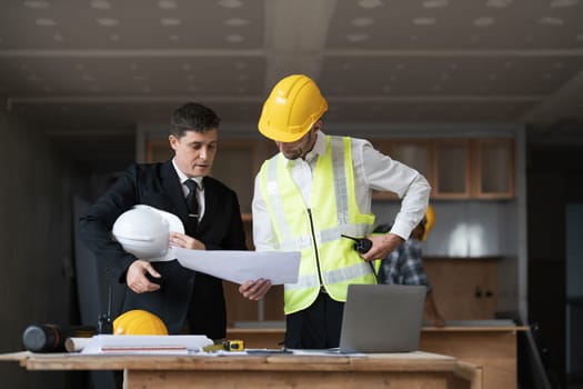 Diverse Team of Specialists Use Laptop on Construction Site. Real Estate Building Project with Engineer Investor and Businessman Checking Area, working on Civil Engineering, Discussing Strategy Plan..