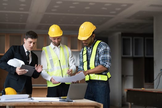 Diverse Team of Specialists Use Laptop on Construction Site. Real Estate Building Project with Engineer Investor and Businessman Checking Area, working on Civil Engineering, Discussing Strategy Plan..