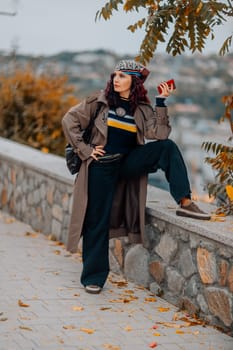 A woman walks outdoors in autumn, enjoys the autumn weather