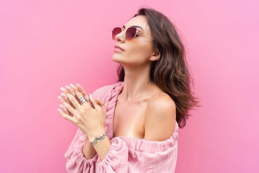 Young beautiful smiling cute romantic woman in trendy summer dress. Carefree woman posing in the street near pink wall. Positive model outdoors in sunglasses. Cheerful and happy.