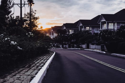 Modern cottages row road sidewalk two story buildings residential villas village New Estate Reflection dawn Sun in windows.