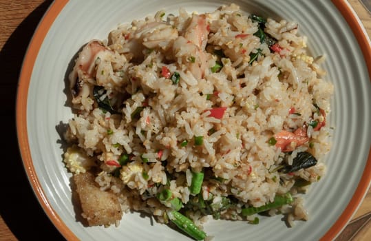 Homemade Holy Basil and Spicy Herb Fried Rice with Shrimps, Squid and Yardlong Bean. Thai Stir Fried Rice with Seafood and Holy Basil Leaf, Asian food style, Space for text, Top view, Selective focus.