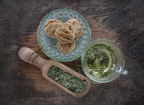 Refreshing and Enjoy with A cup of hot hemp tea (CBD herbal tea) and Dried organic hemp leaves served with Scones on old rustic wooden background. Healthy drink concept. Top view, Space for text.