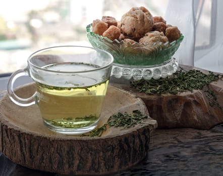 Refreshing and Enjoy with A cup of Hot Hemp Tea (CBD herbal tea) served with Scones and Croutons on old rustic wooden table by the window view with sunlight. Healthy drink concept. Space for text.
