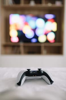 Game controller, joystick on TV screen background. Playing game console, weekend at home, leisure lifestyle concept.