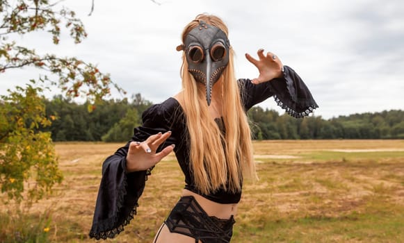 A fascinating and surreal photo of a woman in a crow mask amidst a field and forest.