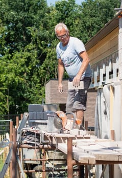 the bricklayer makes the facade of the house from gray bricks with cement and plaster at the construction site. High quality photo