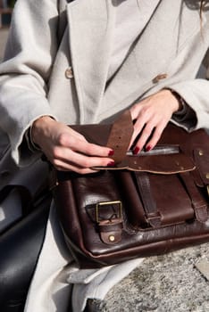 photo of a woman opening a brown leather briefcase with antique and retro look.