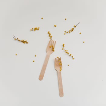 Cutlery with flowers on white textured background. Sustainable lifestyle, no plastic concept, zero waste